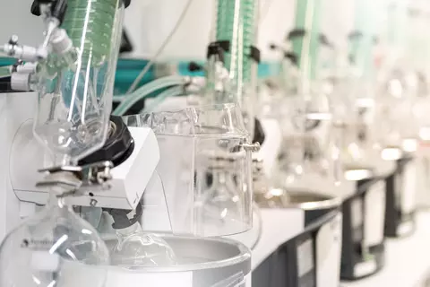 Moderne Laborausstattung mit mehreren Glasapparaturen und Rotationsverdampfern in einer Forschungseinrichtung.