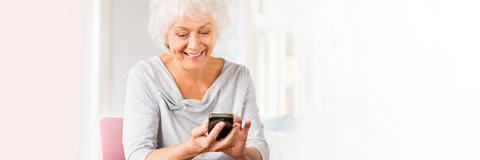 Frau schaut auf ihr Mobil-Telefon